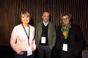 Dame mennesker på konferanse om byrom og fellesskapsdesign i et innendørs møte.