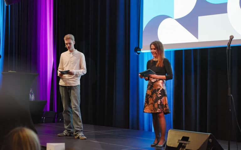 To personer som holder taler på scenen under Hjerterom for byrom arrangementet.