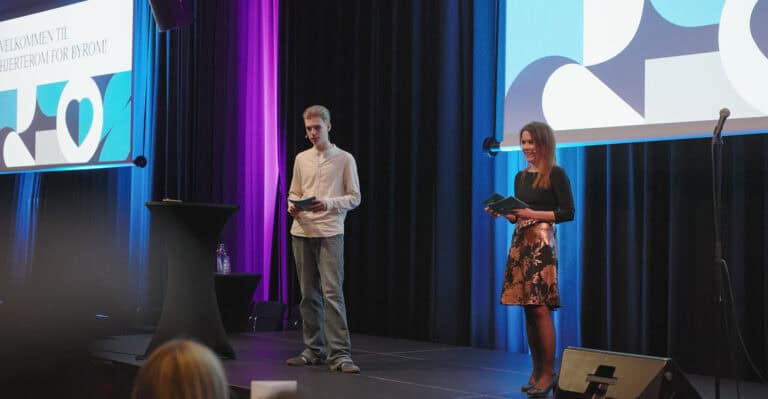 To personer på scen under presentasjon om Hjerterom for byrom.