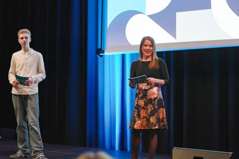 To personer på scen under presentasjon om byrom og fellesskap.