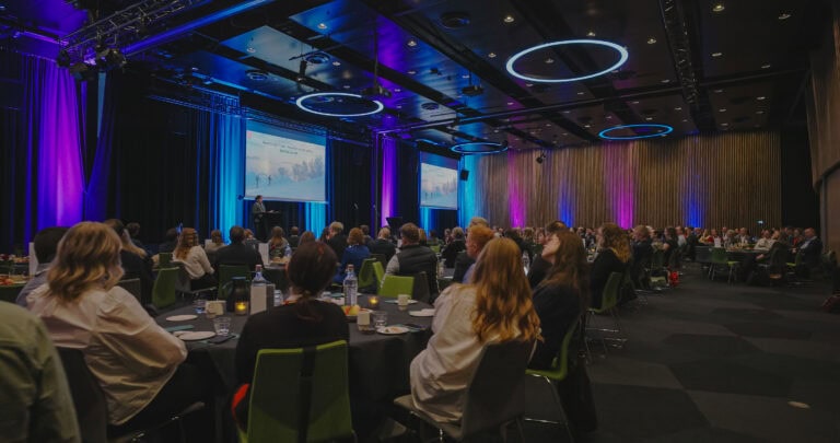 Publikum på konferanse om byrom og byutvikling i et moderne konferanselokale.