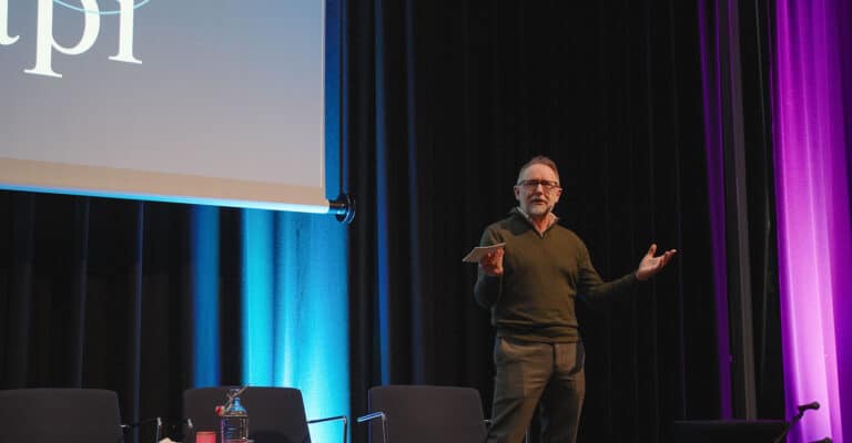 Talende mann på scenen under Hjerterom for byrom konferanse.