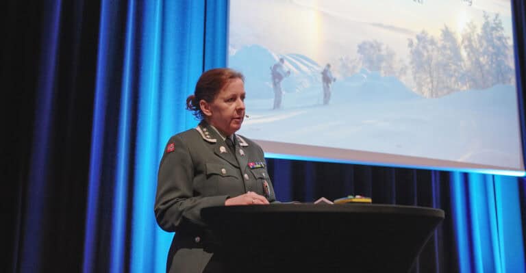 Kvinne i uniform foran presentasjon om byrom og byutvikling.