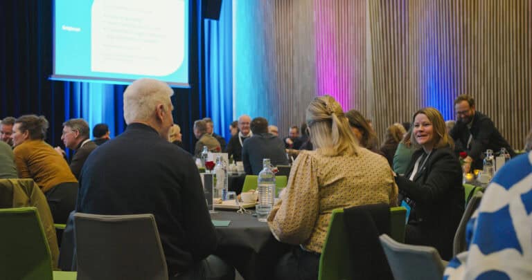 Deltakere i et møte eller seminar i et moderne konferanserom.