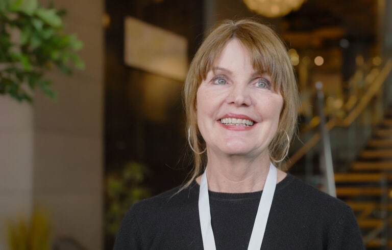 Kvinne smilende i profesjonell setting, representerer Hjerterom for byrom.