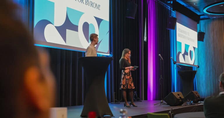 Møte i Hjerterom for byrom med presentasjon på scenen.