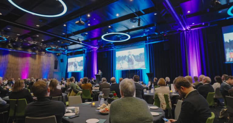 Deltakere på konferanse i Hjerterom for byrom med moderne belysning.