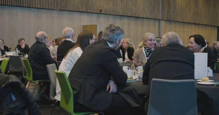Møte i Hjerterom for byrom med engasjerte deltakere rundt bordet.