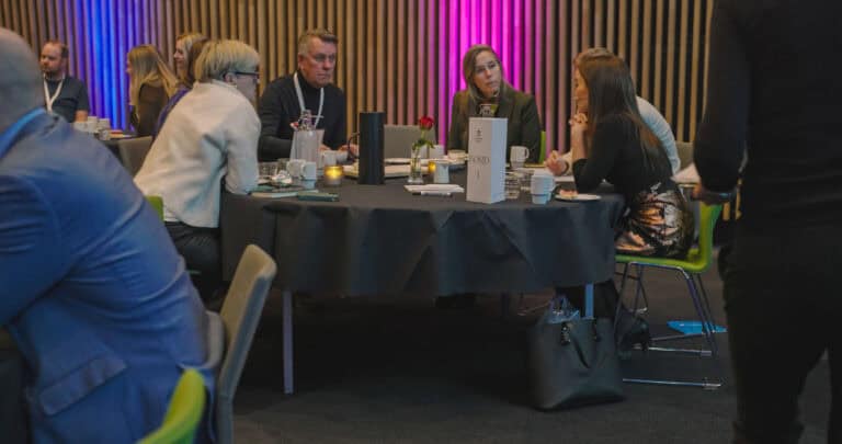 Gruppe mennesker i møte på Hjerterom for byrom, diskuterer og samarbeider.