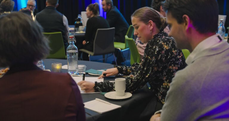 Møte i Hjerterom for byrom med engasjerte deltakere rundt bordet.