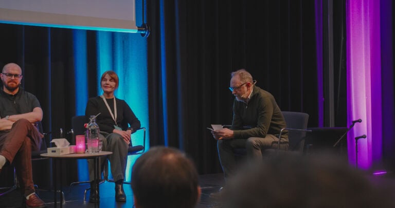 Paneldiskusjon om byrom og fellesskap i et auditorium.