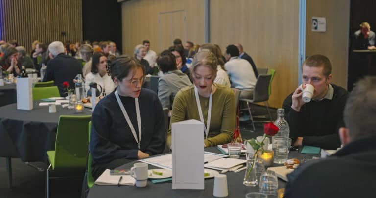 Hjerterom for byrom: Nettverksmøte med engasjerte deltakere i et konferanserom.
