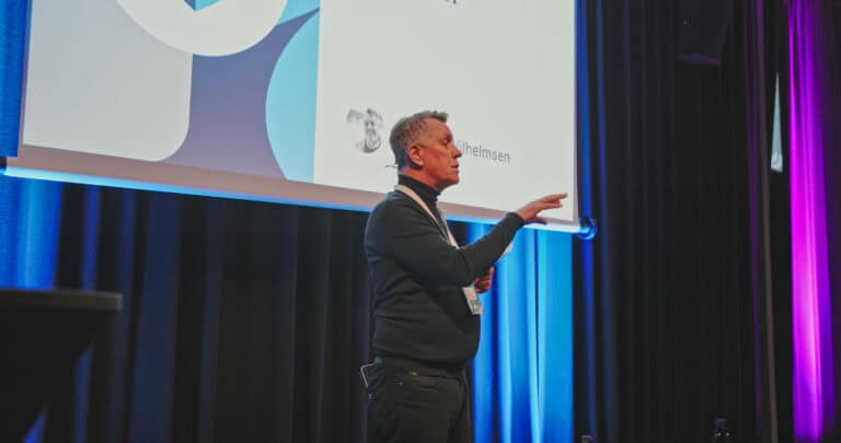 Person som holder foredrag på scenen under Hjerterom for byrom arrangementet.