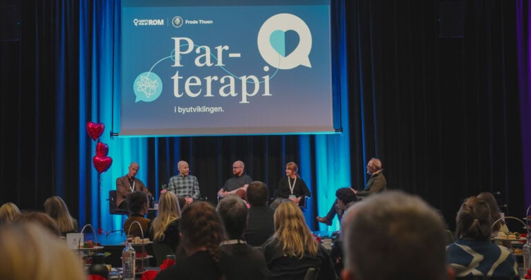 Paneldiskusjon om parterapi under konferanse i byrommet.