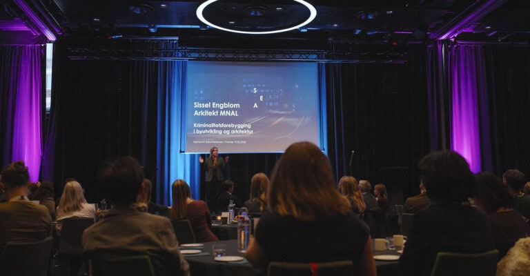Profesjonell presentasjon på konferanse i Hjerterom for byrom, med publikum og speaker.