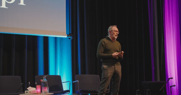 Mann holder foredrag på scenen under Hjerterom for byrom arrangementet.