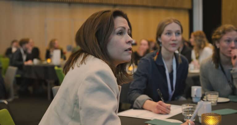 Deltakere i et byromsmøte i Hjerterom, engasjerte i diskusjon om byutvikling.